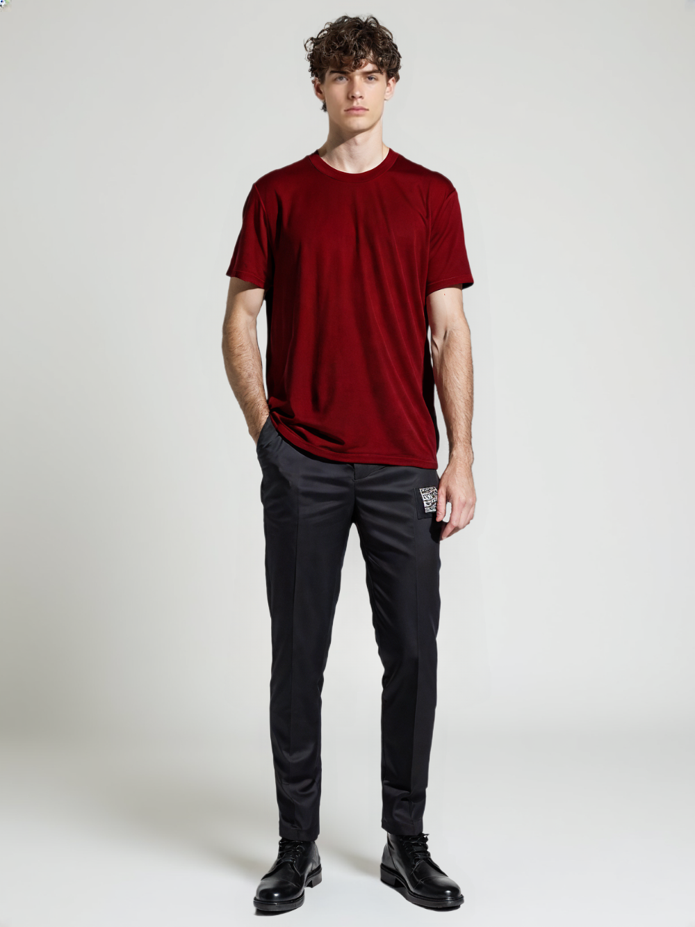 Man wearing a classic red t-shirt for men paired with black pants and black shoes in a studio