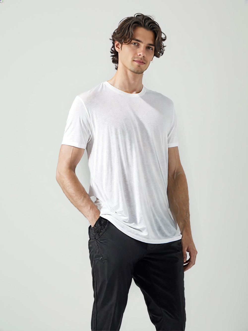 Male model wearing classic white t-shirt with short sleeves and a round neck paired with black pants